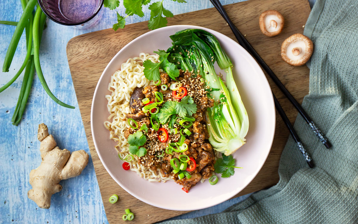 Tallrik med Anammas asiatiska färssås med nudlar, pak choi och salladslök.